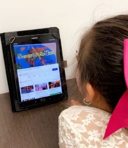 Young girl watching Secrets of the Heart TV on an iPad.